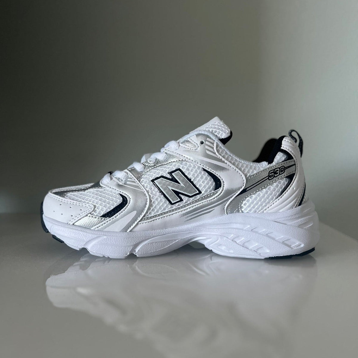 Zapatillas para niños premium modelo 530 blanca con detalles negros tallas 30-35